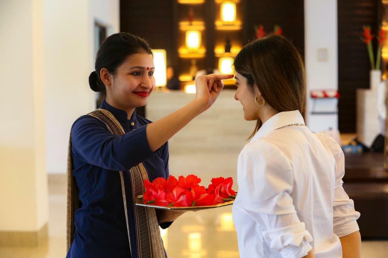 트리덴트 아그라 호텔 외부 사진 A hotel staff welcoming a guest