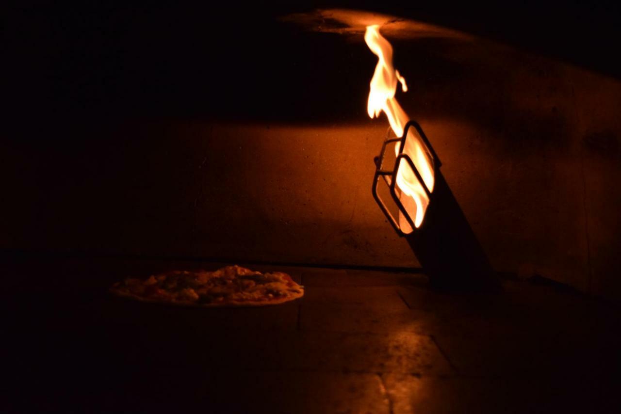 트리덴트 아그라 호텔 외부 사진 A pizza baking in a wood-fired oven